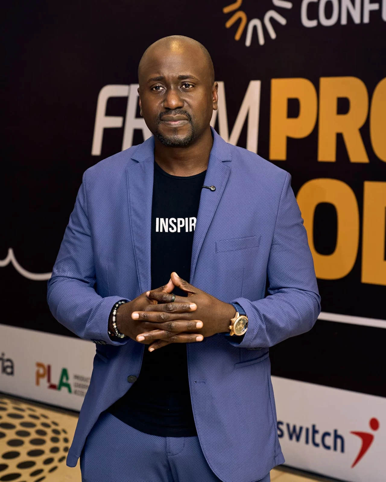 Christian Idiodi in a blue jacket in front of a conference backdrop