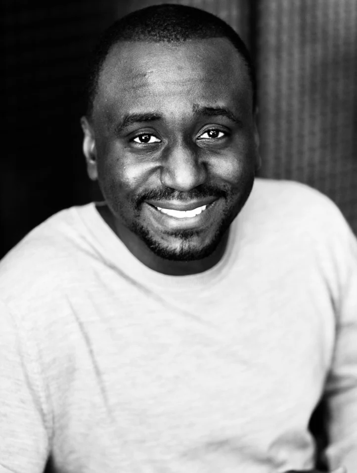 Black-and-white portrait of Christian Idiodi smiling