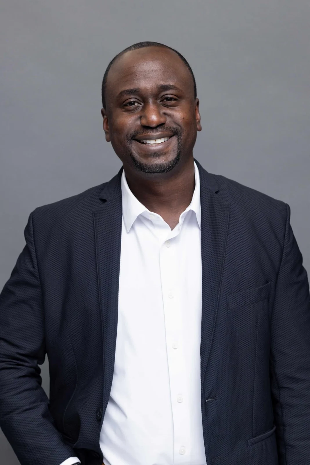 Christian Idiodi standing against a gray studio background